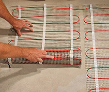 Installing radiant floor heating mat.