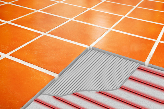 A heated tile floor with illustration of cutaway showing the enbedded heat cable. A heated tile floor with cutaway showing heat cable and thinset.